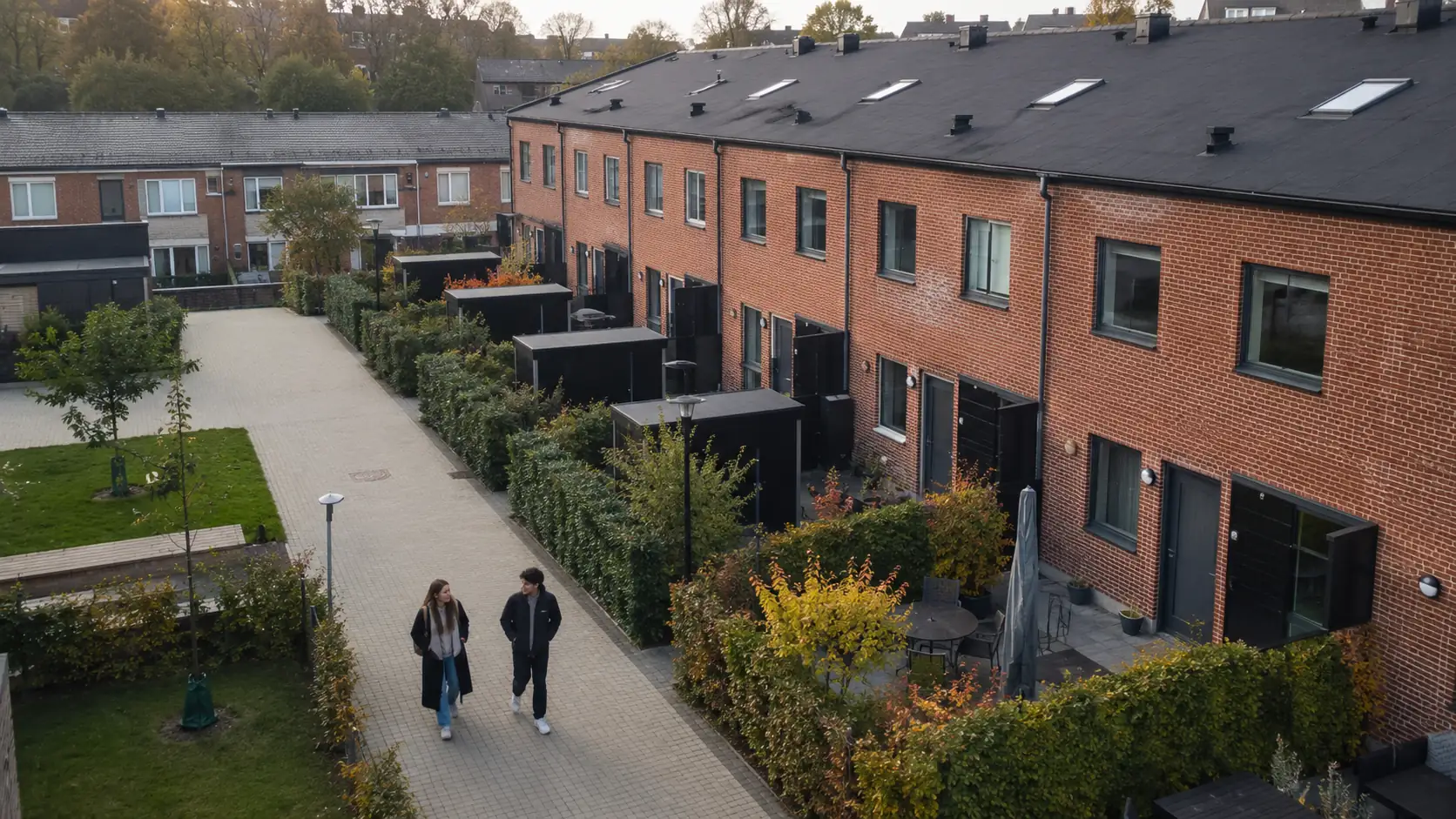 Two younger people walking in an area with houses